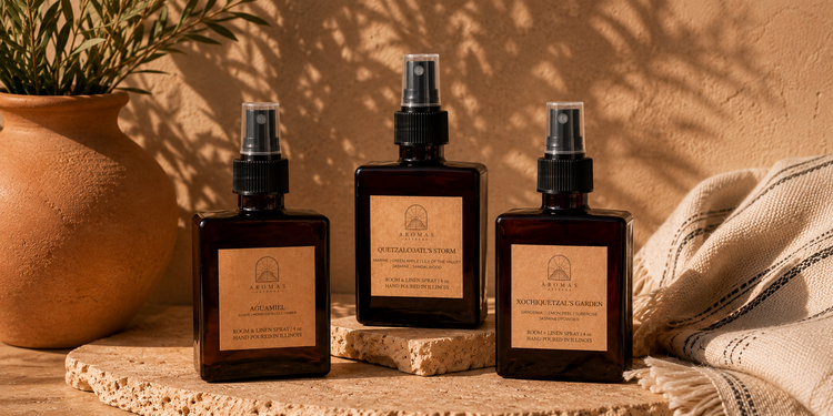 Three Aromas Aztecas room and linen sprays featuring Aguamiel, Quetzalcoatl's Storm, and Xochiquetzal's Garden arranged with terracotta pottery and warm earthy décor.