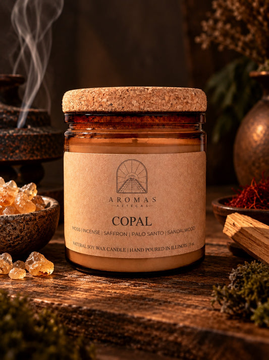 Aromas Aztecas Copal candle in an amber glass jar with a cork lid, displayed on a rustic wooden surface in a dark, moody setting with warm amber lighting, incense smoke, copal resin, saffron, palo santo, and moss subtly arranged around it.